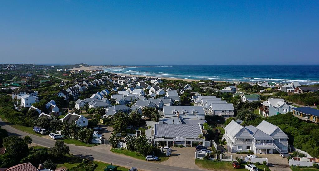 an aerial view of a neighborhood with houses and the ocean at Cape St Francis Resort in Cape St Francis