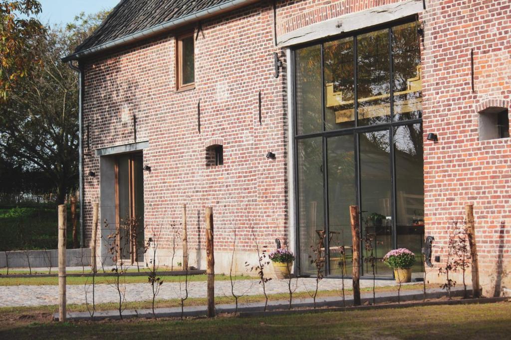 a brick building with glass windows and potted plants at Duisbeke Logies in Oudenaarde