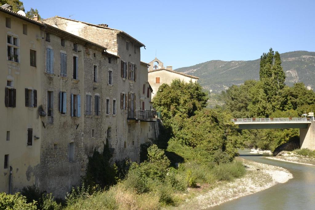 an old building next to a river with a bridge at Gîte &#39;An Kay Ou&#39; - Le Grand Barry in Pontaix