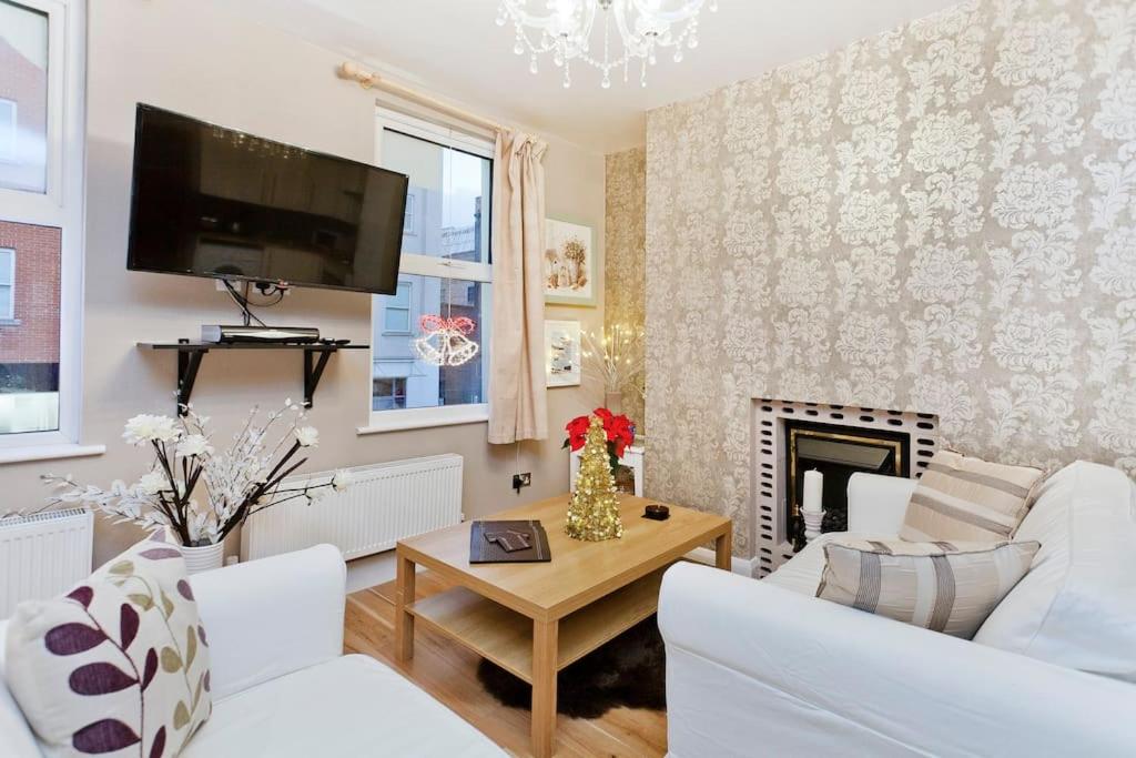 a living room with white furniture and a fireplace at Whole house in Central Camden Town in London