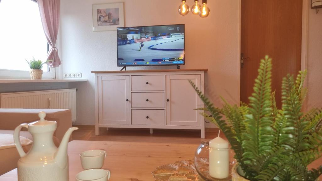 a living room with a tv on top of a dresser at Appartement im Silwai 4 in Westerland