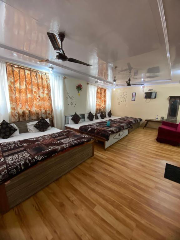 a bedroom with four beds and a wooden floor at Hotel Young Mamta in Srinagar