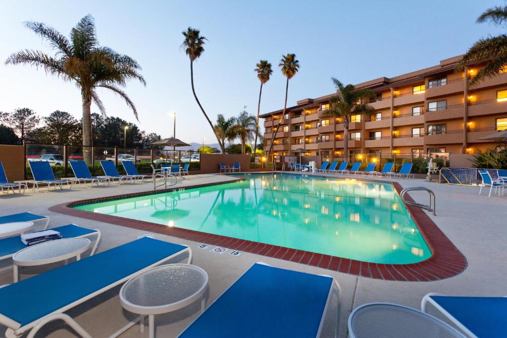 a swimming pool with chairs and a hotel at Holiday Inn & Suites Santa Maria, an IHG Hotel in Santa Maria