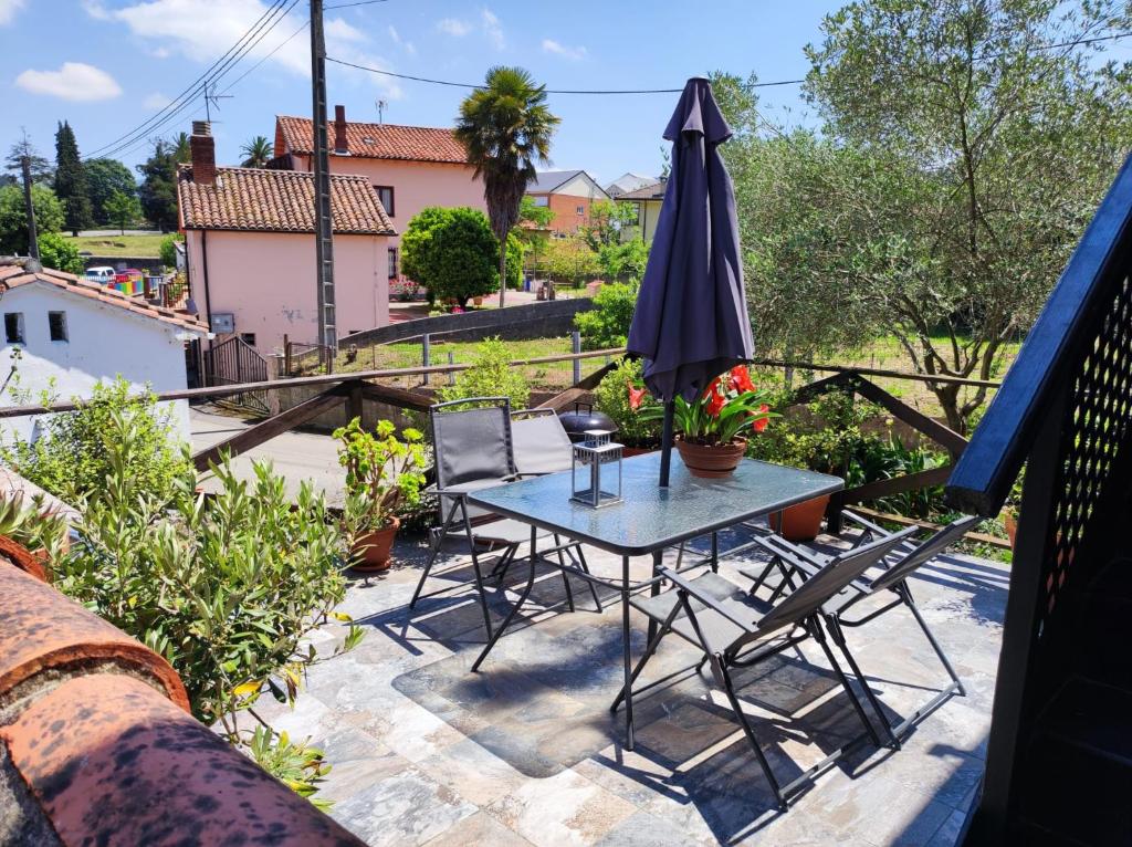 un patio con mesa, sillas y sombrilla en Apartamento El Olivo, en Villabáñez