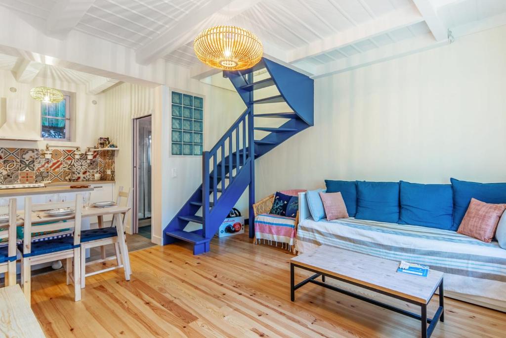 a living room with a blue couch and a staircase at Charming fisherman house in the center of Trouville - Welkeys in Trouville-sur-Mer