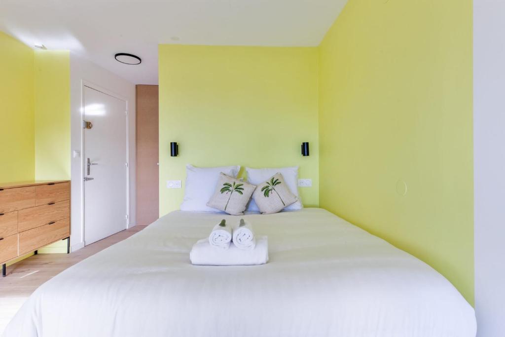 ein Schlafzimmer mit einem großen weißen Bett mit zwei Schuhen darauf in der Unterkunft Brand new studio with sea view in the Deauville port - Welkeys in Deauville