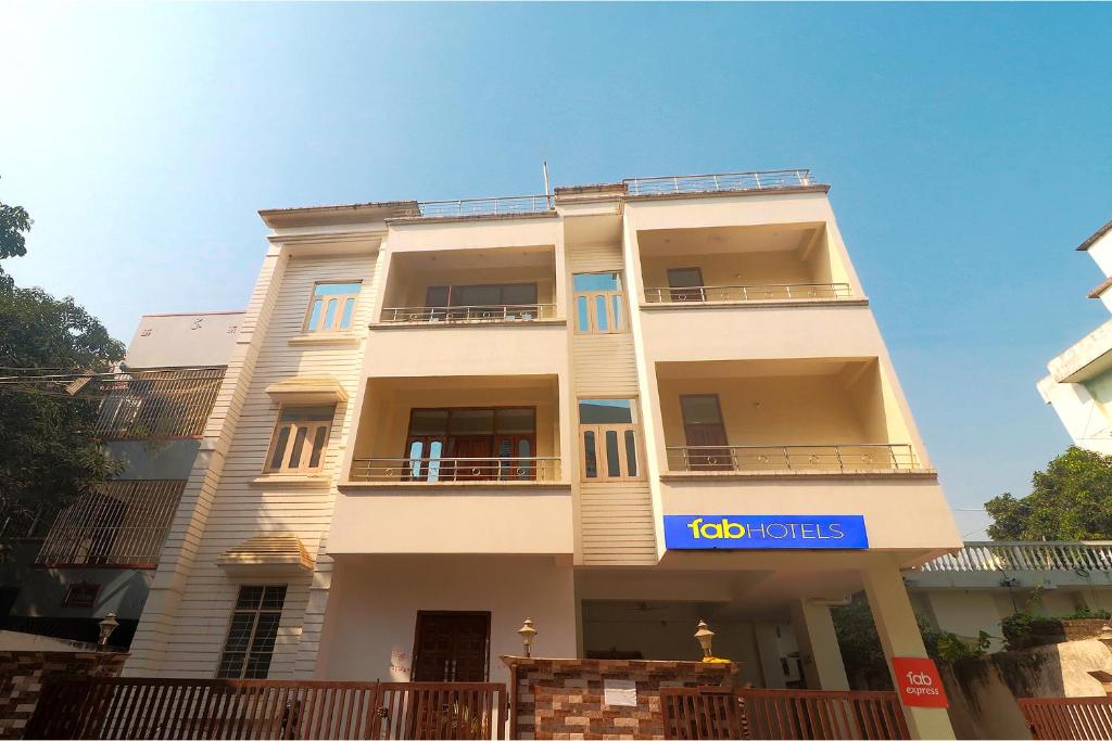 un grand bâtiment blanc avec un panneau bleu dans l'établissement FabExpress Buddha Residency, à Patna