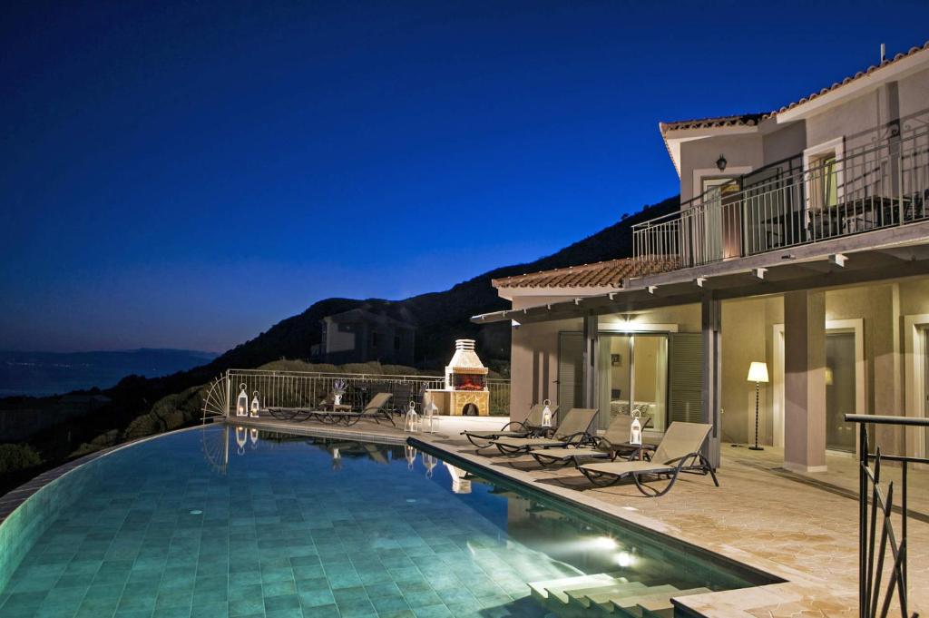 uma villa com piscina à noite em Villa Agriada by Villa Plus em Spathíon