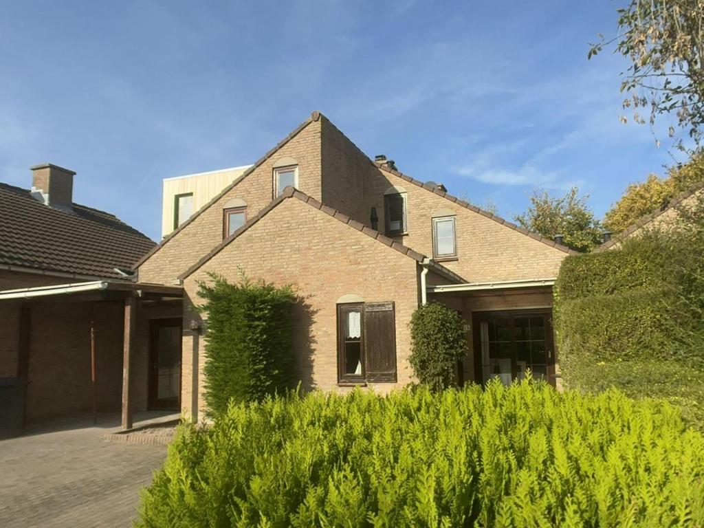 a brick house with a window and bushes at Spaanse Galeienstraat 75 in Retranchement