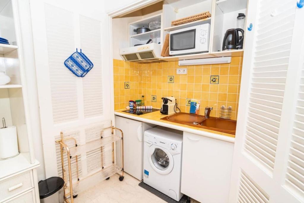 a small kitchen with a sink and a washing machine at Cosy Studio Cannes Center beaches shopping and congresses LIVE IN MERLE in Cannes