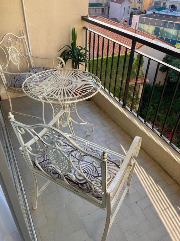 a balcony with a table and a table and a chair at Cosy Studio Cannes Center beaches shopping and congresses LIVE IN MERLE in Cannes