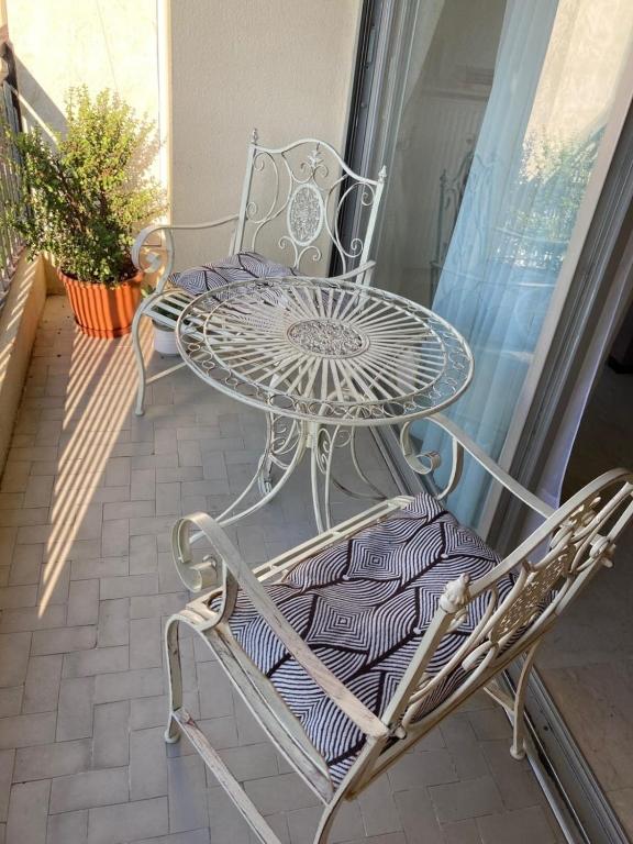 a glass table and chairs on a balcony at Cosy Studio Cannes Center beaches shopping and congresses LIVE IN MERLE in Cannes