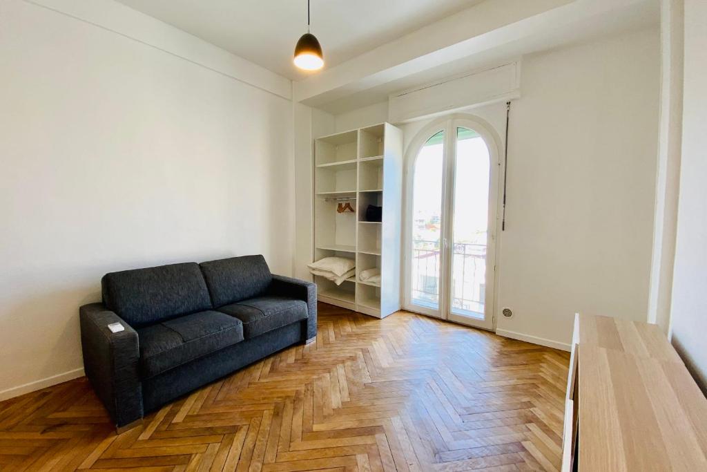 ein Wohnzimmer mit einem Sofa und einem Fenster in der Unterkunft Design apartment ideal for seaside holidays LIVE IN DR FABRE in Juan-les-Pins