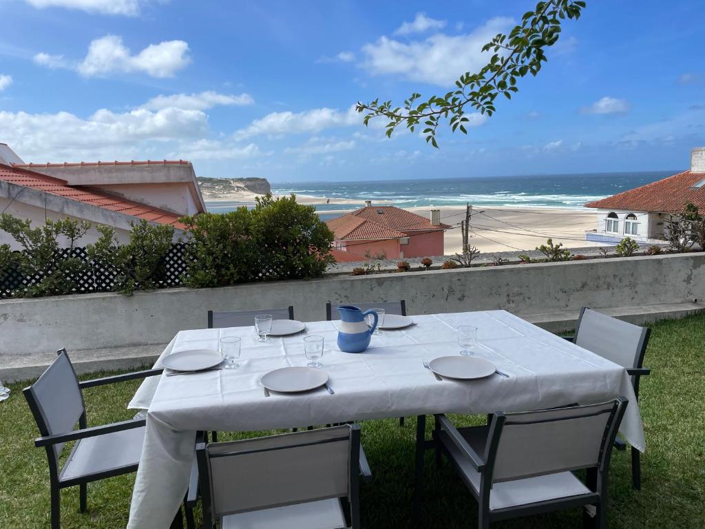 einen weißen Tisch mit Stühlen und Meerblick in der Unterkunft Foz - Sea View Cottage in Foz do Arelho