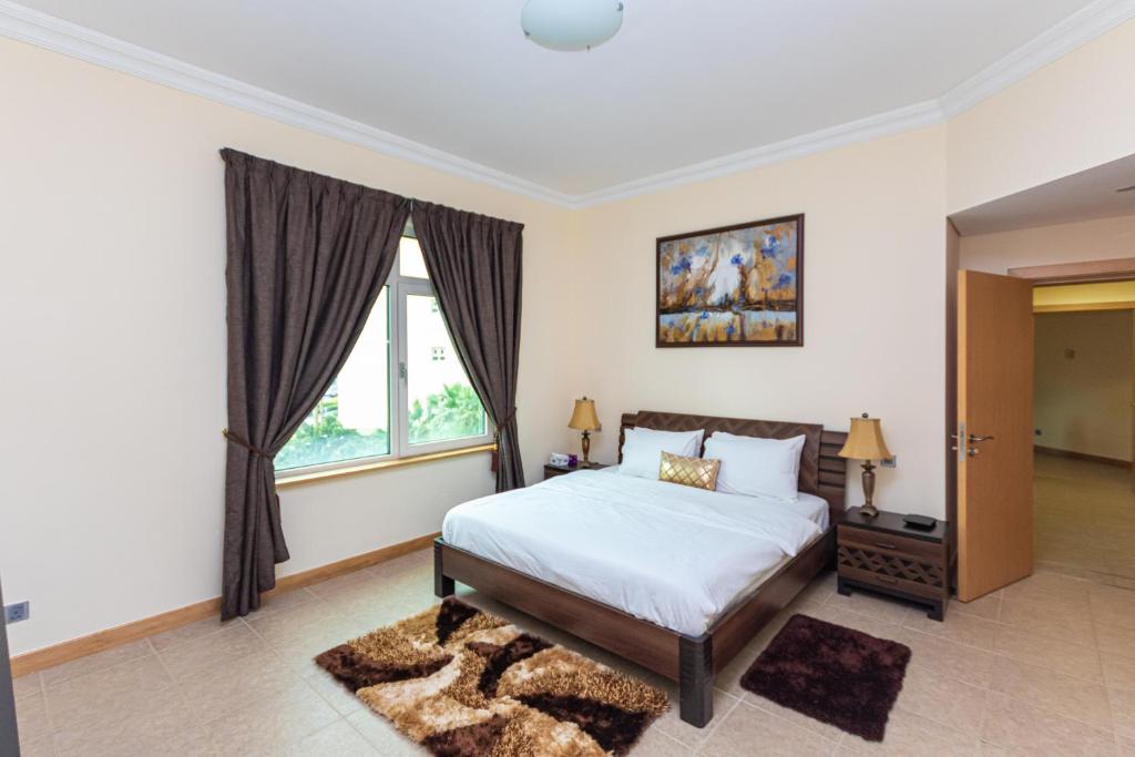 a bedroom with a bed and a window at Palm Jumeirah Dubai 2 Bed in Dubai