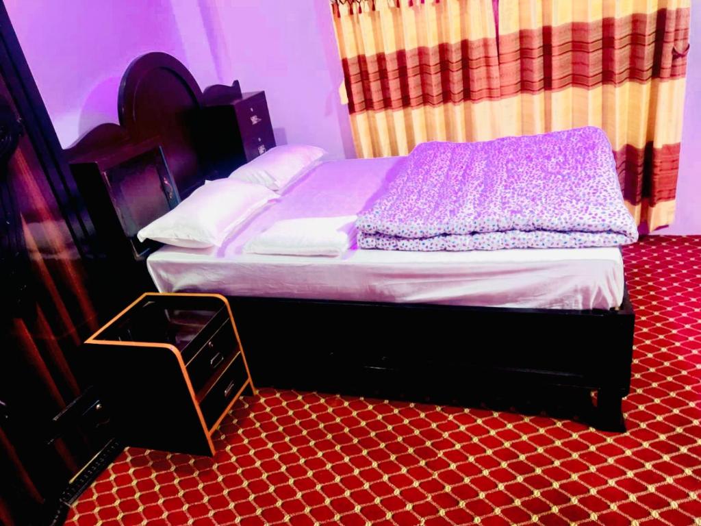 a small bed in a room with a red floor at Hotel Sauraha Gaida House in Chitwan