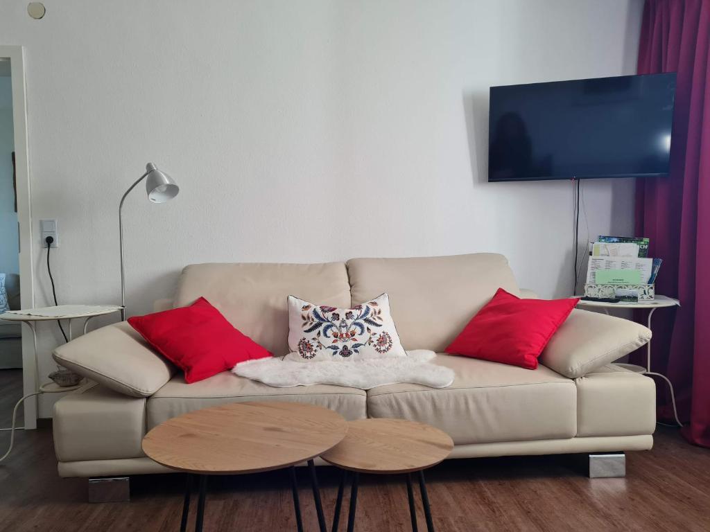 sala de estar con sofá y almohadas rojas en Ferienwohnung Forsthaus, en Bad Grönenbach