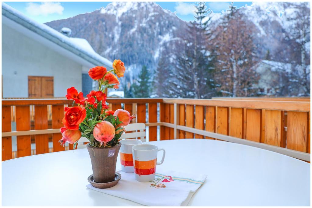 a vase with flowers on a table on a balcony at [Casa Quadrifoglio] a 3 minuti dalle piste da sci in Gressoney-Saint-Jean