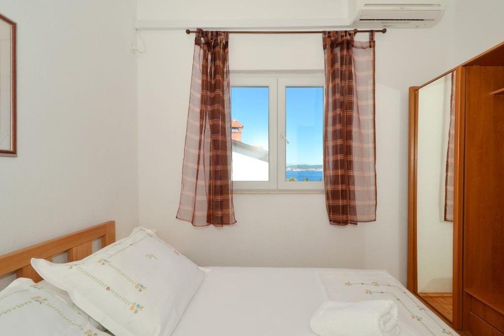 a bedroom with a bed and a window at Apartment in Seget Vranjica with sea view, balcony, air conditioning, WiFi 91-2 in Seget Vranjica