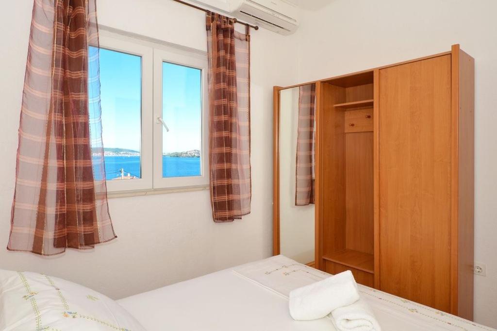 a bedroom with a bed and a window at Apartment in Seget Vranjica with sea view, balcony, air conditioning, WiFi 91-2 in Seget Vranjica