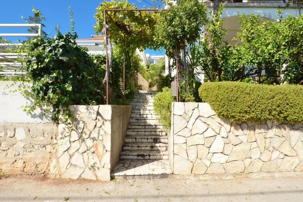a set of stairs with a stone wall and trees at Apartment in Seget Vranjica with sea view, balcony, air conditioning, WiFi 91-2 in Seget Vranjica