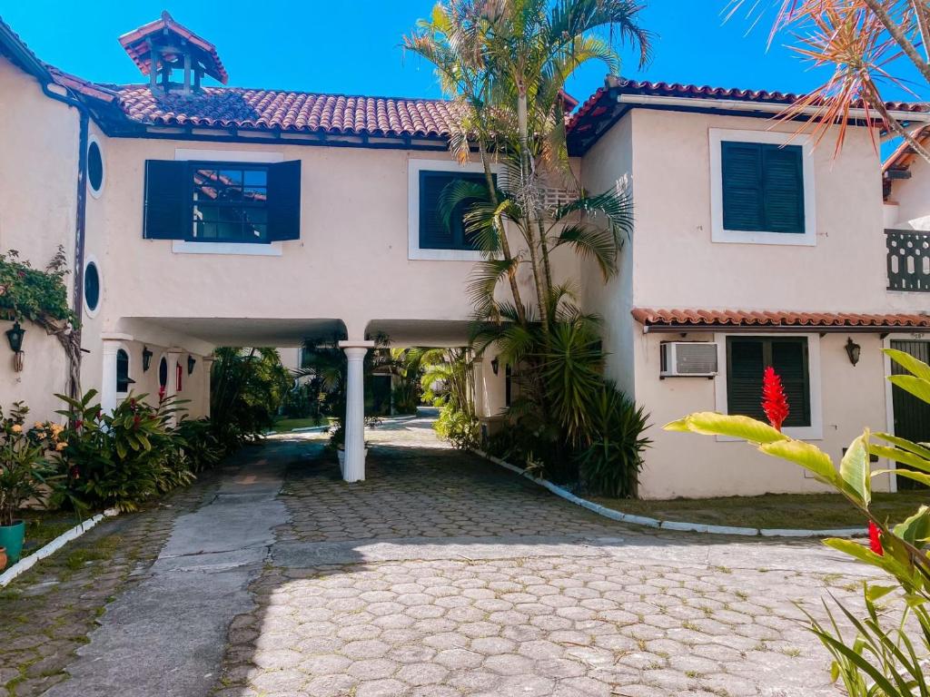 a large white house with a driveway at Casa Vila da Praia Buzios - Centro in Búzios