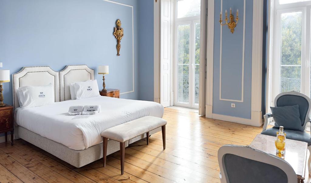 a bedroom with a large white bed and blue walls at Casa do Principe in Lisbon