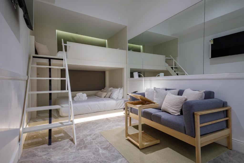 1 dormitorio con literas, sofá y escalera en Charterhouse Causeway Bay, en Hong Kong