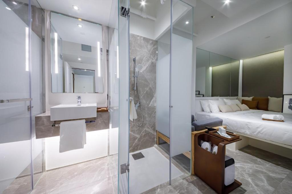 bagno con doccia, letto e lavandino di Charterhouse Causeway Bay a Hong Kong