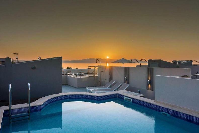 Una piscina en lo alto de un edificio con una puesta de sol. en Villa Miami, en Nea Kydonia