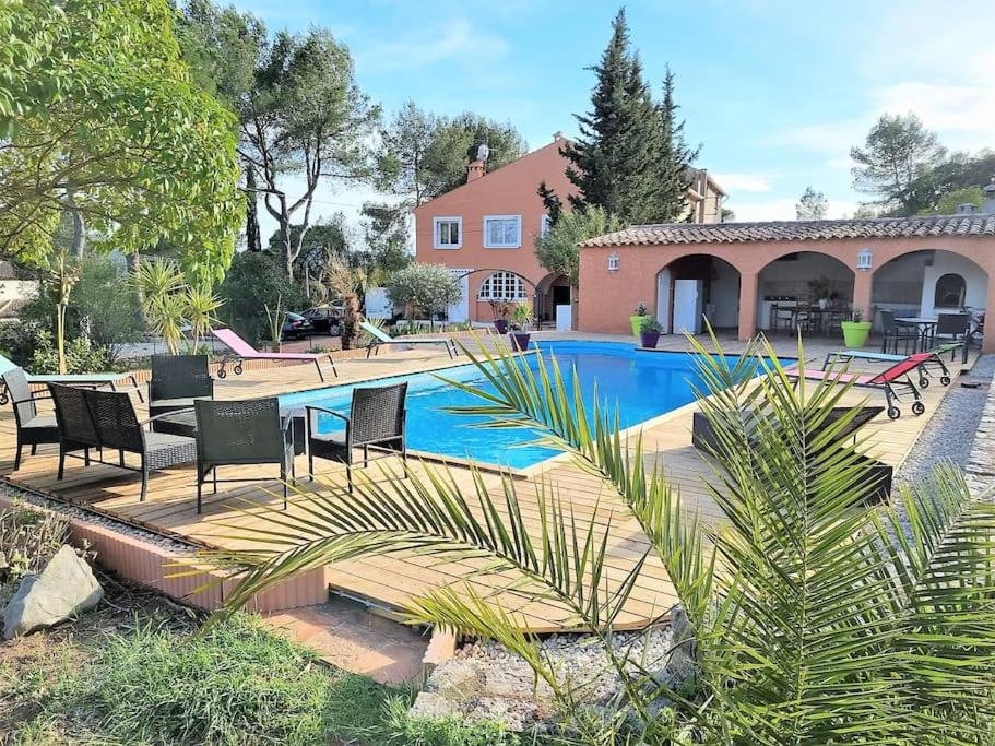 a swimming pool with chairs and a house at VILLA avec piscine - 4 chambres - parking - calme in Les Arcs sur Argens