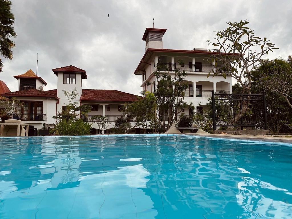a large blue swimming pool in front of a building at Elegant Hotel in Kandy