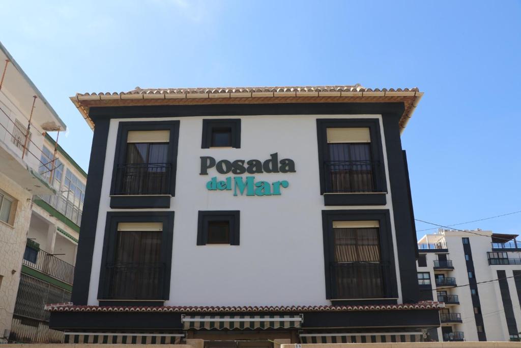 un edificio con un cartel en el costado en 102 I Posada del Mar I Encantador hostel en la playa de Gandia, en Los Mártires