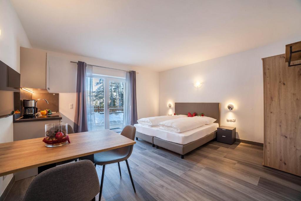 une chambre d'hôtel avec un lit, une table et une cuisine dans l'établissement Ferienwohnung Berger, à Avelengo