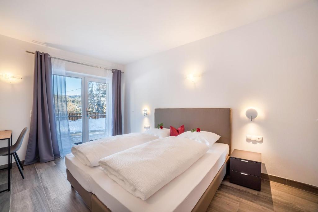 a large white bedroom with a large bed and a window at Ferienwohnung Bergerr in Avelengo