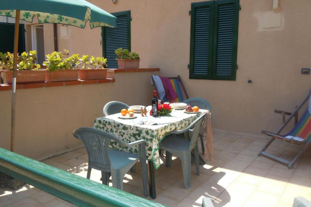 una mesa y sillas en un patio con mesa en Il Quadrifoglio 4 en Procchio