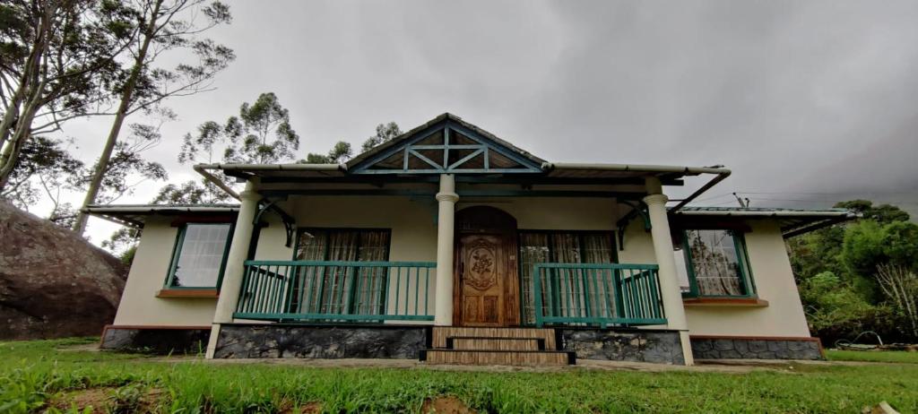 Cette petite maison dispose d'une terrasse couverte et d'une porte. dans l'établissement Green House Rock Home Stay, à Chinnakanal