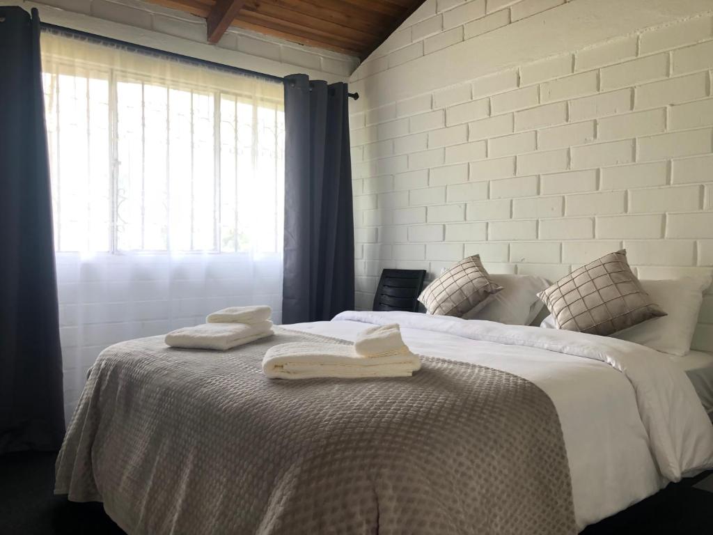 a bedroom with two towels on a bed with a window at High-end Holiday Cabin - Tungurahua Hot Springs in Baños
