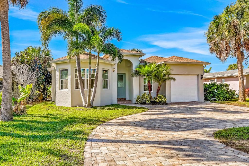 a house with palm trees in front of a driveway at Indian Rocks Beach Hideaway in Clearwater Beach