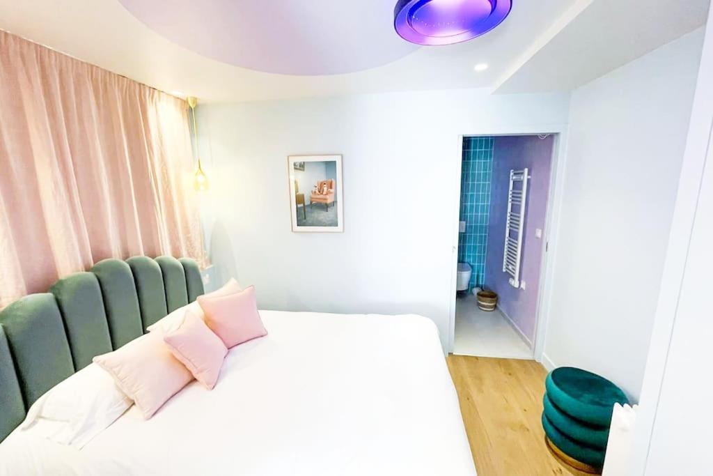 sypialnia z łóżkiem i zielonym krzesłem w obiekcie Appartement Aquaroom RDC - Plage 50m - Rue gratuite w Saint-Malo