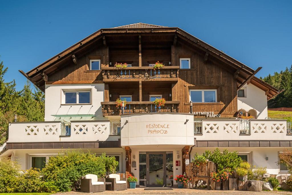 a large wooden house with a balcony at Residence Prapoz in Ortisei