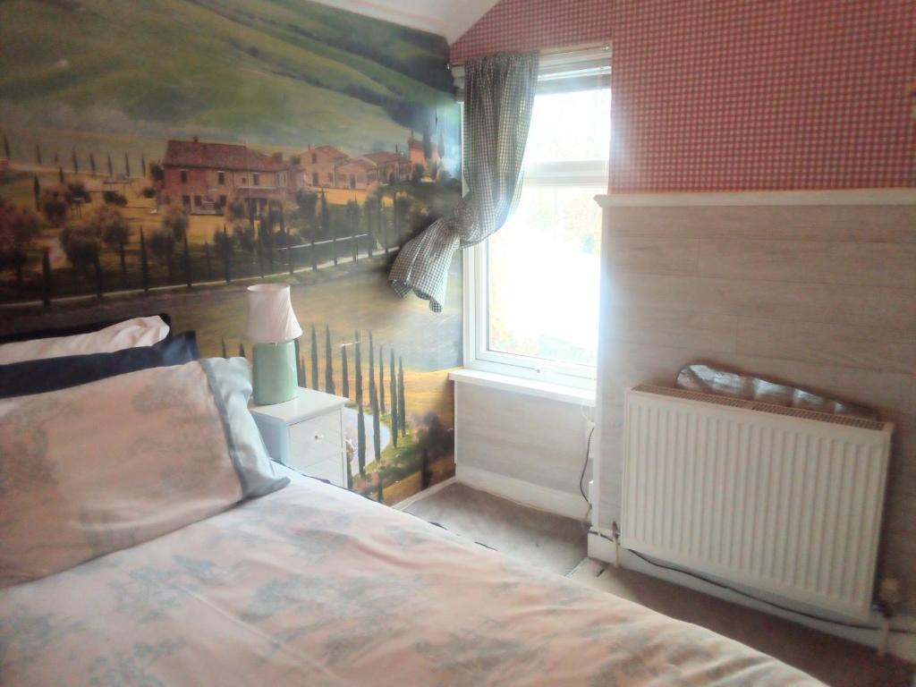 Homestay Cardiff في كارديف: غرفة نوم بسرير ودهان على الحائط