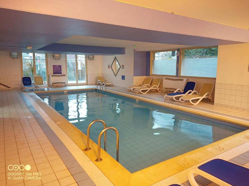 einen großen Pool mit Stühlen und einem Pool in der Unterkunft Bergheim Piscine in Bergheim