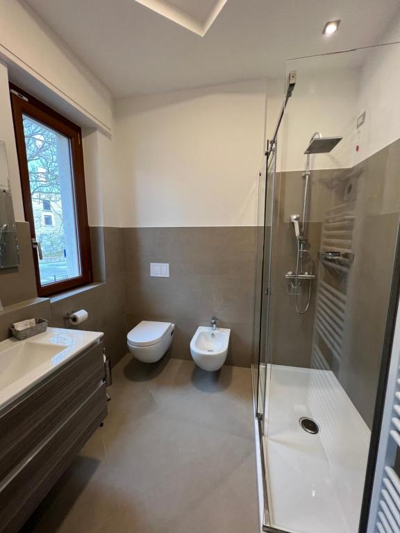 a bathroom with a shower and a toilet and a sink at Rainbow Hotel Depandance Joli in San Marino