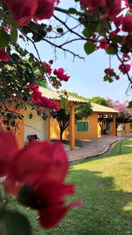 a building with pink flowers in front of it at Hotel Fazenda Cachoeiras Serra da Bodoquena in Bodoquena