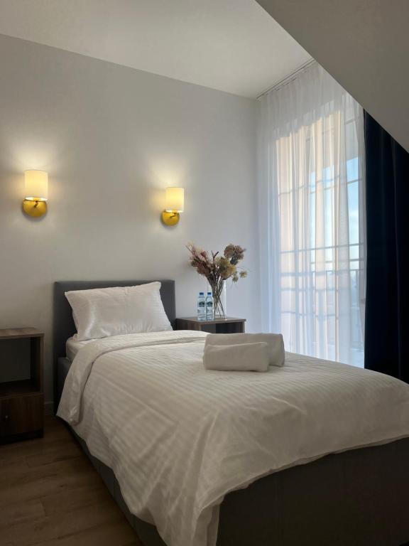 una camera da letto con un grande letto bianco con una finestra di Adzikowy Dworek a Wyszków