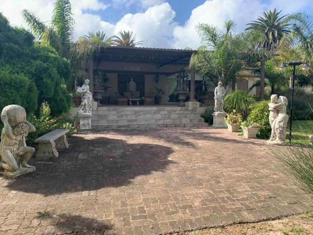 una casa con estatuas frente a un patio en Palm Villa, en Sunlands