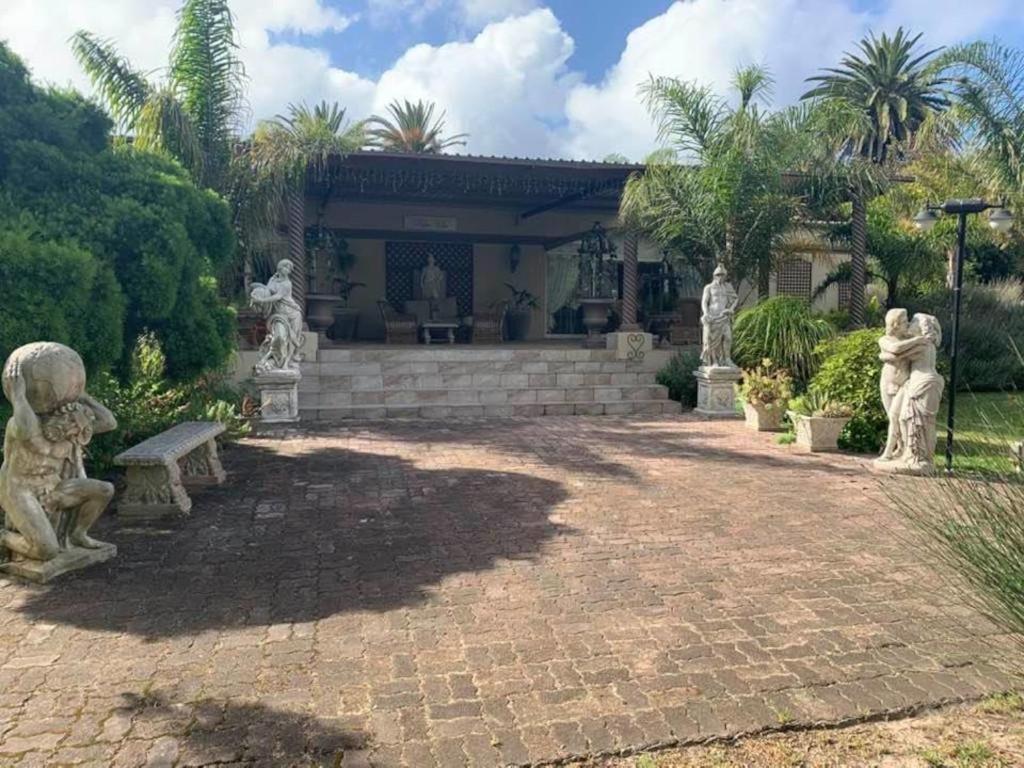 a house with statues in front of a patio at Palm Villa in Sunlands
