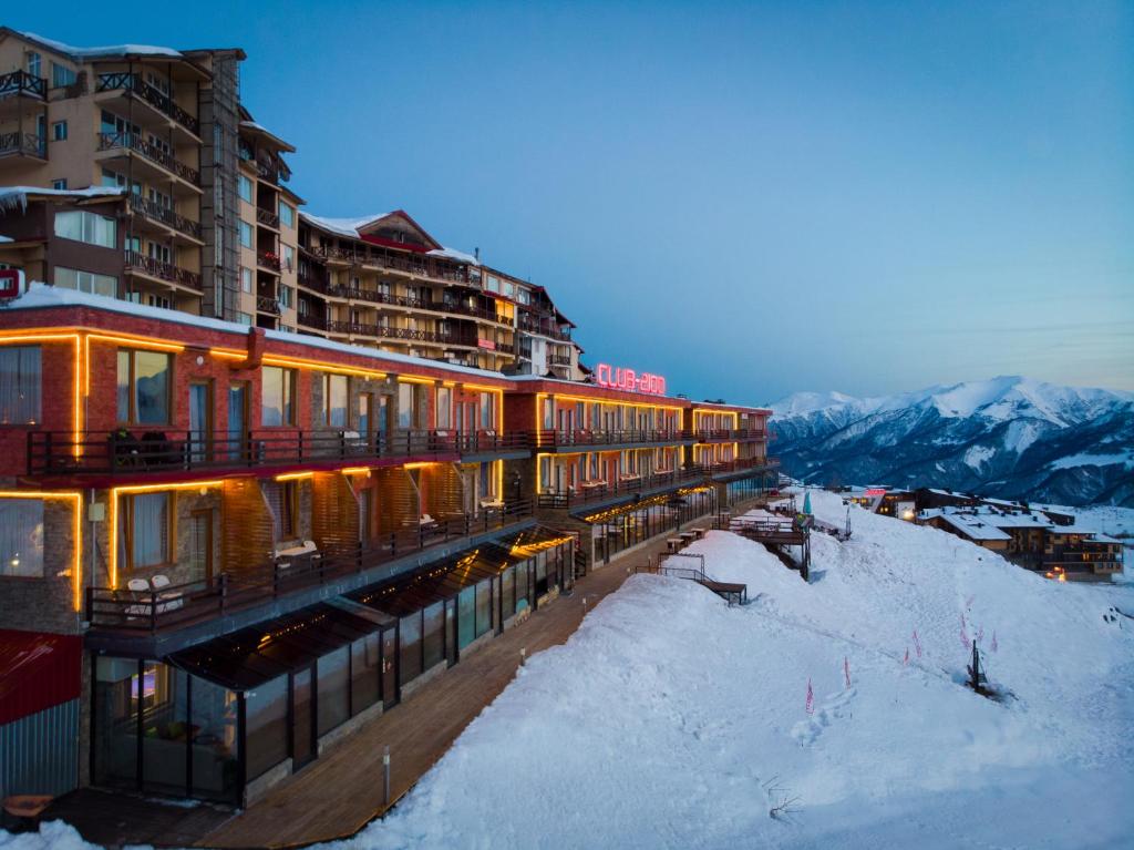 un hotel en las montañas con nieve en el suelo en Hotel Club-2100 en Gudauri
