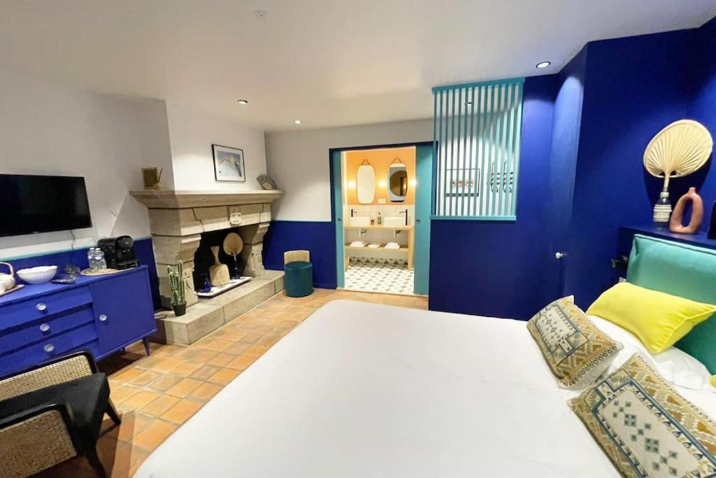 een blauwe slaapkamer met een bed en een open haard bij Chambre Majorelle - RDC - Plage 50m - Rue gratuite in Saint-Malo